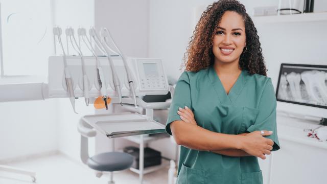 Smiling dentist standing in their office