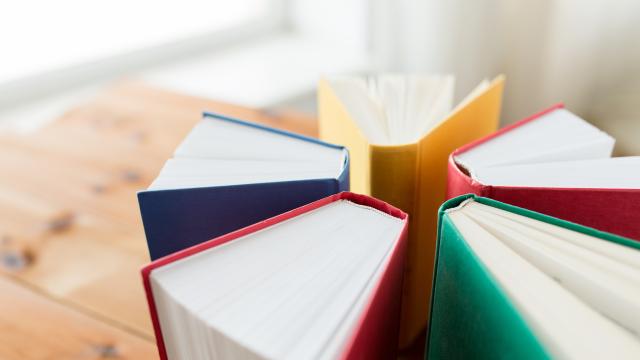 Five primary color covered books standing in circle on a table.