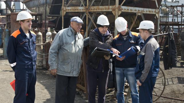Engineers discuss plans at the shipyard