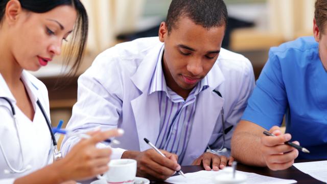 Two medical specialists looking at their papers during a meeting.