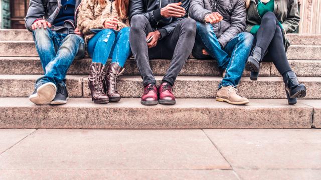 Image of young adults from the neck down sitting on steps