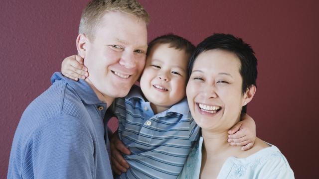 A portrait of a smiling family of three.