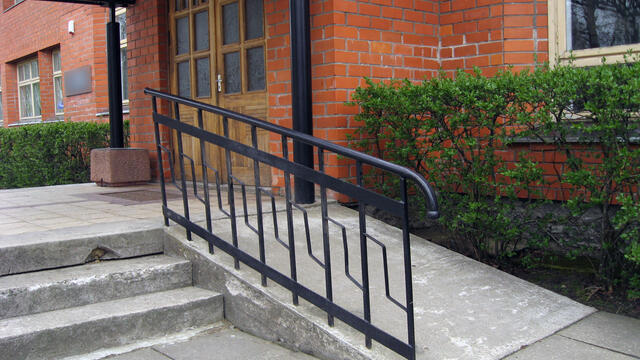 A ramp next to steps at a building.