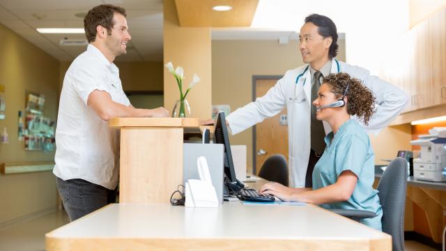 Adult talking to doctor and receptionist in physician's office