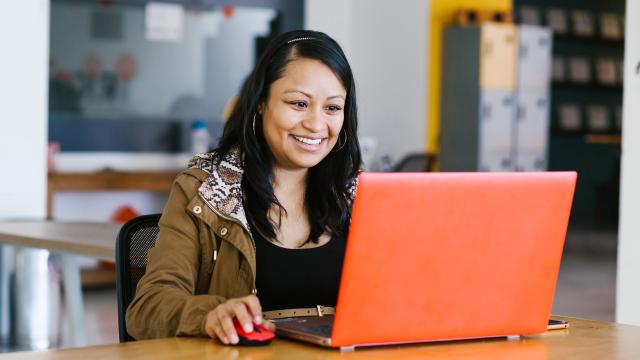 Person sitting at a table working on a laptop