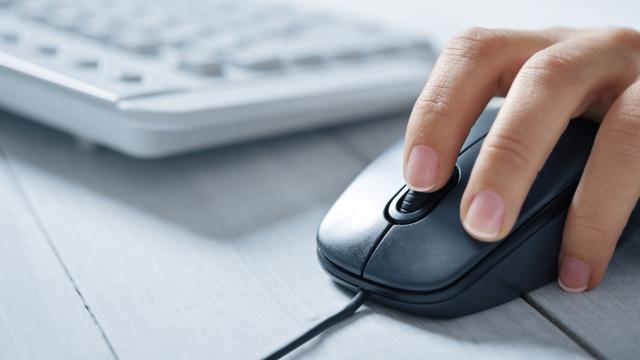 A hand on computer mouse with a keyboard