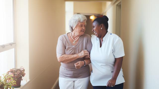 Two adults chatting while walking down a hallway