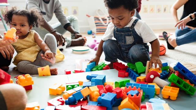 Children playing with legos on the floor