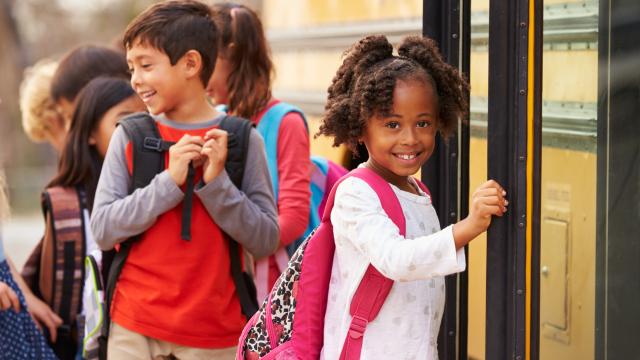 Young children getting on a school bus