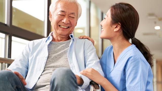 An older adult laughing with their caregiver