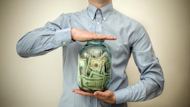 Adult torso and arms holding a large jar of money