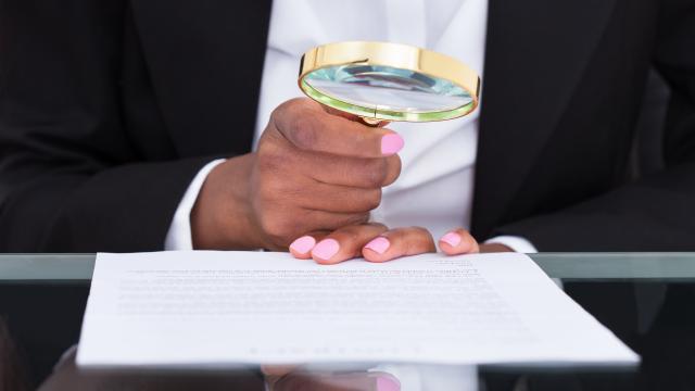 Person using a magnifying glass to read