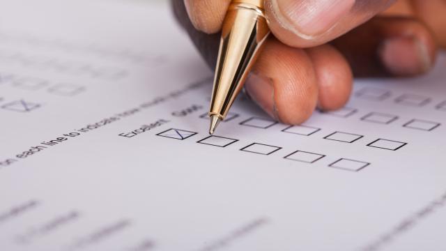 Close up of hand and pen completing a survey