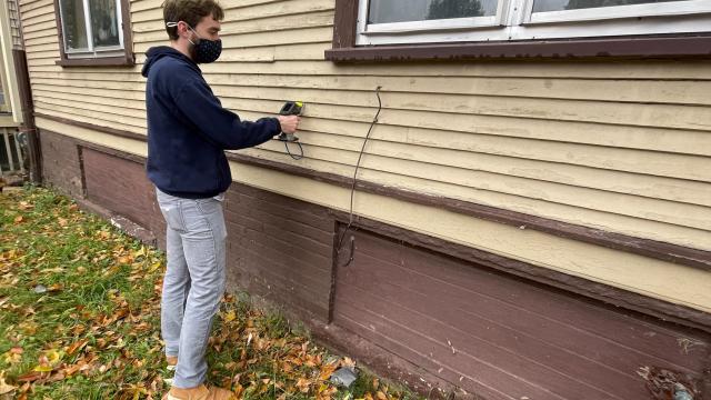 Person performing a lead testing risk assessment on a house