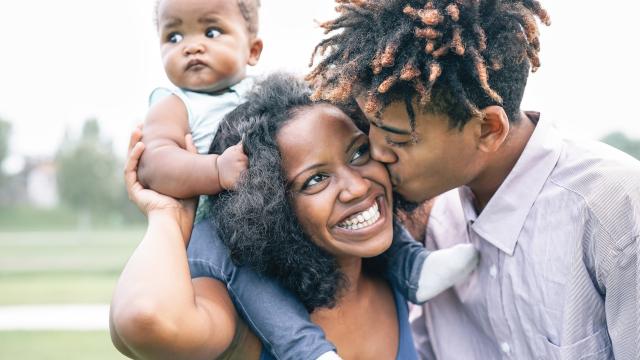 A happy family of three outside.