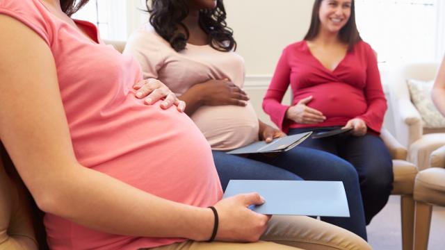 Three pregnant women sit in a circle at a pre natal class