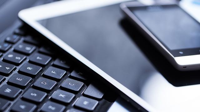 Keyboard with a tablet and smart phone laying on it