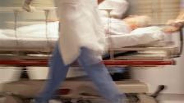 Blurred image of a patient being wheeled in a gurney in a hospital.