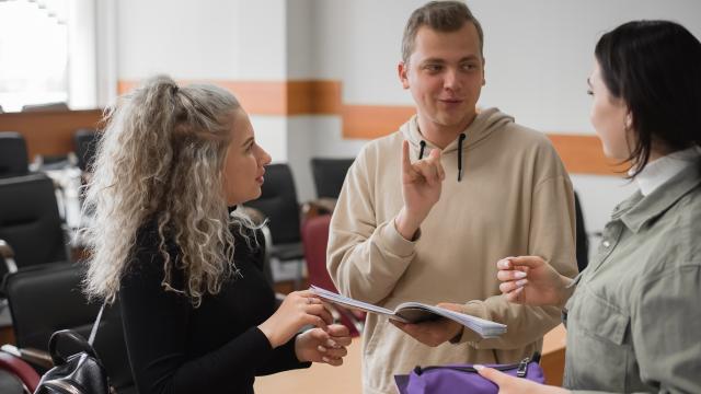 Three adults using sign language to communicate