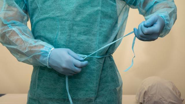 Adult typing a disposable gown