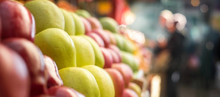 close up rows of red,yellow, reddish and green apples in food counter at food store