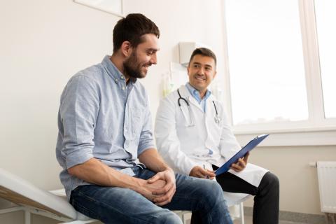 Doctor with clipboard talking with an adult