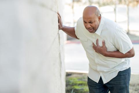 An adult bends over in pain with hand on chest.