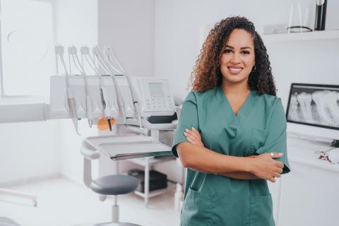 Smiling dentist standing in their office