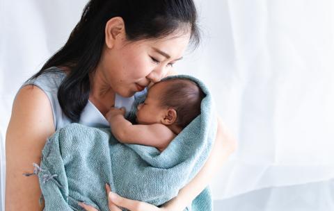 Adult holding infant bundled in a blanket