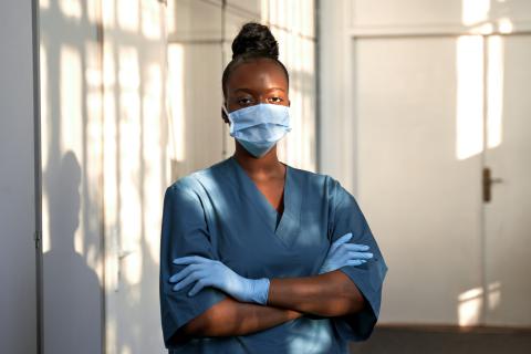 An adult wearing a mask and scrubs