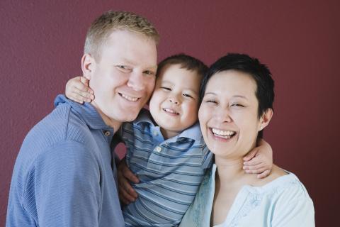 A portrait of a smiling family of three.