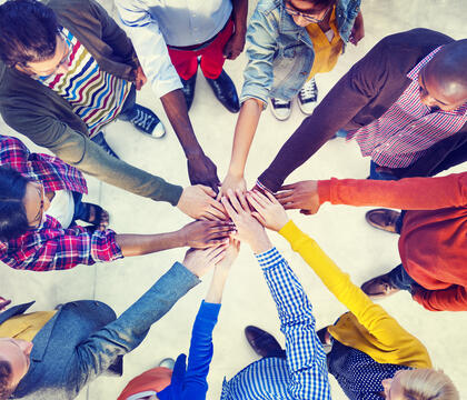 Hands in circle stacked together.