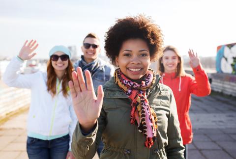 Group of smiling people waving