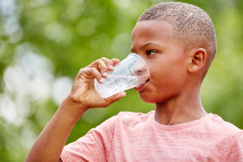 Close up of a child drinking a glass of water