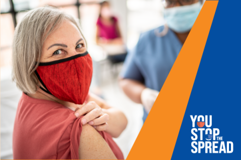 You Stop the Spread, adult wearing a red mask holding her sleeve up waiting for a vaccine