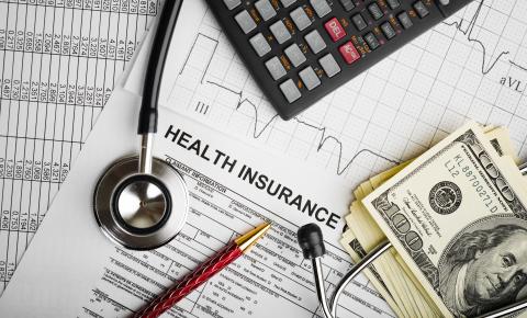 Spreadsheets, health insurance application, stethoscope, pen, calculator, money
