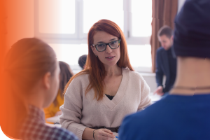 Person talking with two other people in a room