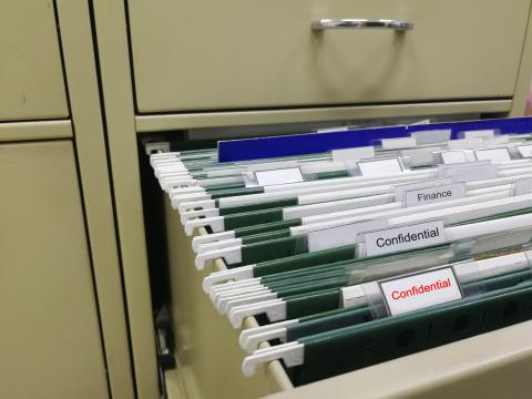 File drawer full of folders labeled confidential