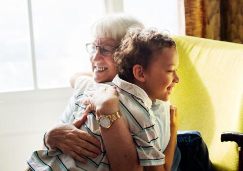 An older adult hugging a child