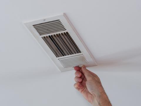 Hand adjusting an HVAC vent