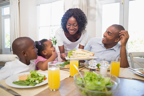 Family of four have healthy food for a meal at home.