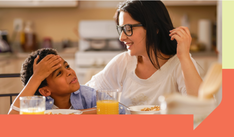 A mother and son talking over breakfast in a kitchen