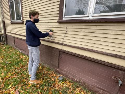 Person performing a lead testing risk assessment on a house