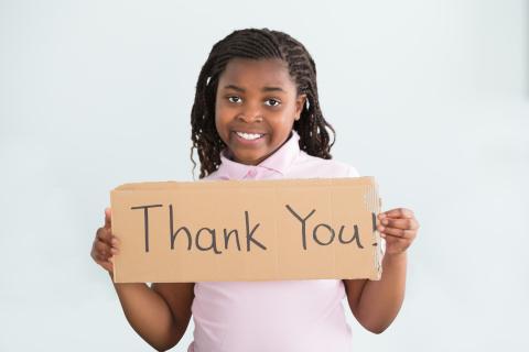 Child holding a Thank You sign