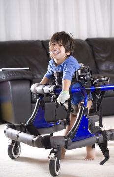 Young child uses a walker while smiling at the camera