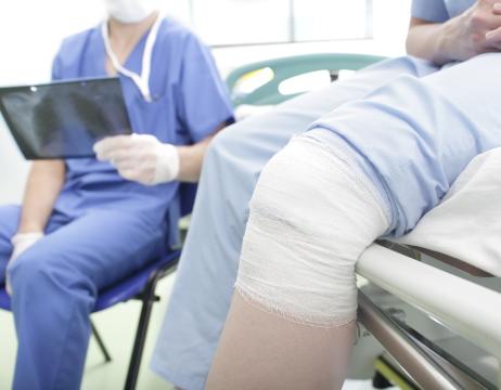 Doctor holding x-ray with patient who has a knee injury