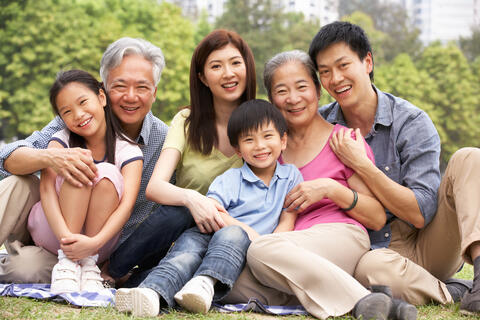 Three generation family poses in a park