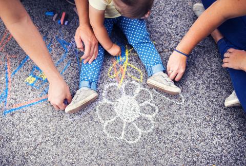 Family draws using sidewalk chalk