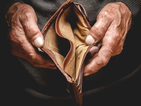 Older adult hands holding an open empty wallet