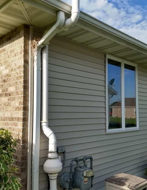 Radon mitigation system outside of a house.